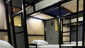 A bunk bed room with a wooden headboard and a white mattress. - Milo's Hostel and Residences  (Santa Ana)