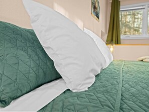 A bed with a green quilt and white pillows. - Clean & Cozy | Pet Friendly Cabin at Hatcher Pass (Palmer)