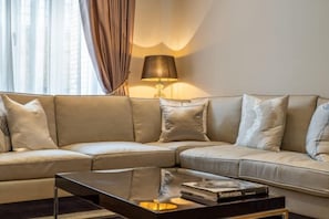 A modern living room with a sectional sofa, a glass coffee table, and a floor lamp. - Royal Mayfair Villa (London)