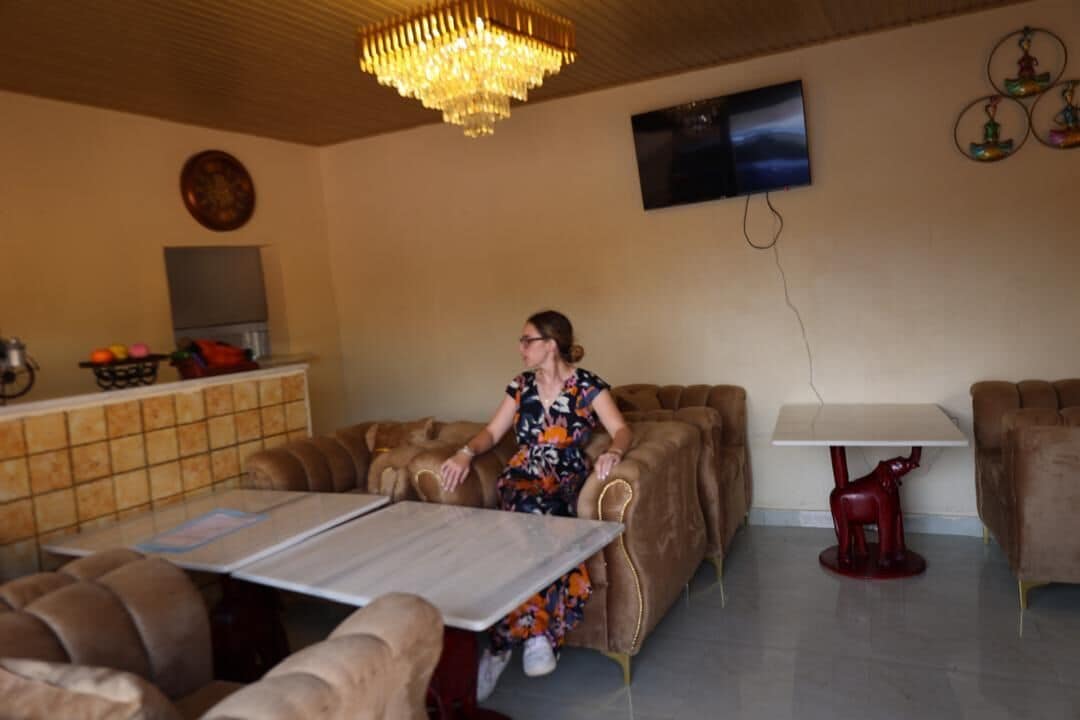 A living room with a sofa, a table, and a TV mounted on the wall.