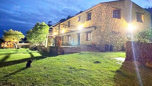 Un edificio de piedra con un césped cuidado y una escalera visible que conduce a la entrada.