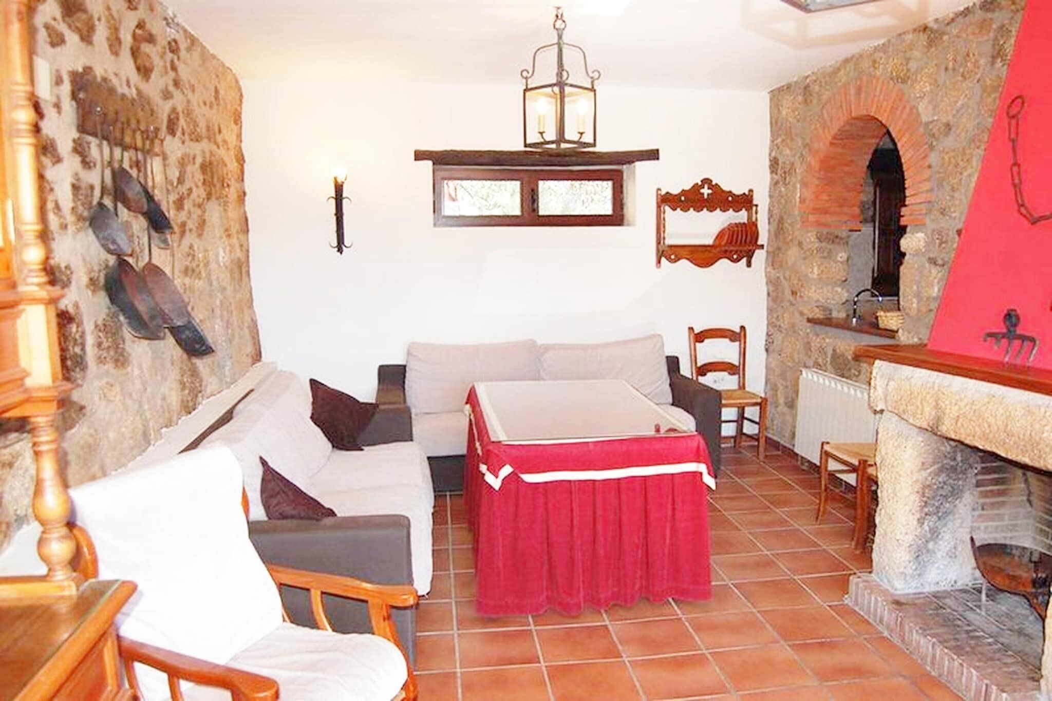 Una habitación acogedora con chimenea, sofá, mesa y candelabro.