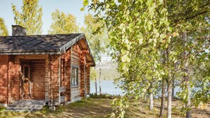 A rustic cabin with a wooden exterior, a chimney, and a small porch. - Sunday Morning Resort (Pelkosenniemi)