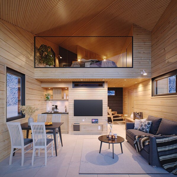 A modern loft-style living space with a dining area, kitchen, and a cozy seating area.