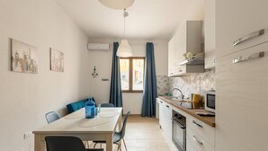 Een gezellige keuken met een eethoek, met een tafel, stoelen en een raam met gordijnen.