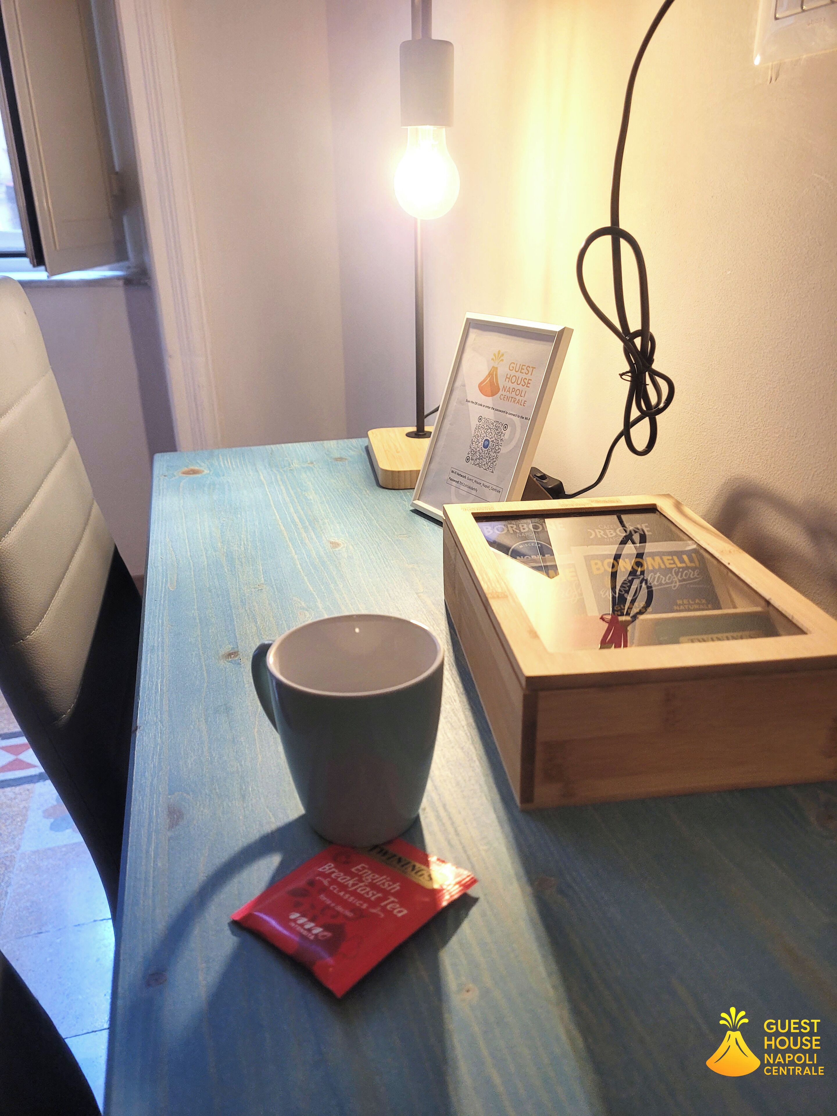 A table with a cup, a framed picture, and a small box.