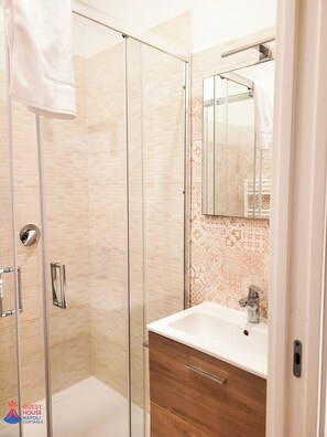 Habitación doble | Baño | Regadera, secadora de cabello, pantuflas, toallas