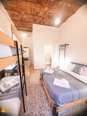 Habitación cuádruple | Escritorio, espacio para trabajar con laptop y cortinas blackout