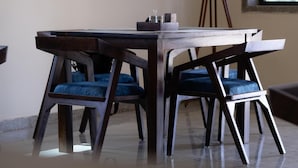 Un coin repas avec une table et des chaises en bois, un lampadaire et une fenêtre donnant sur un beau paysage.
