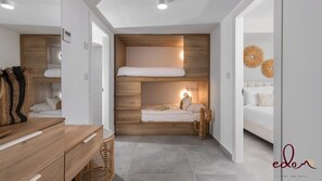 Une chambre moderne et compacte, dotée d’un lit superposé, d’un bureau en bois et d’un petit coin salon.