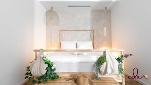 Een slaapkamer met een bed, nachtkastjes en een hanglamp.
