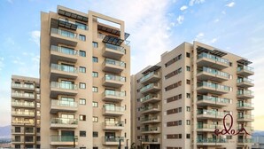 Un edificio residenziale moderno a più piani, con balconi, ampie finestre e pannelli solari.