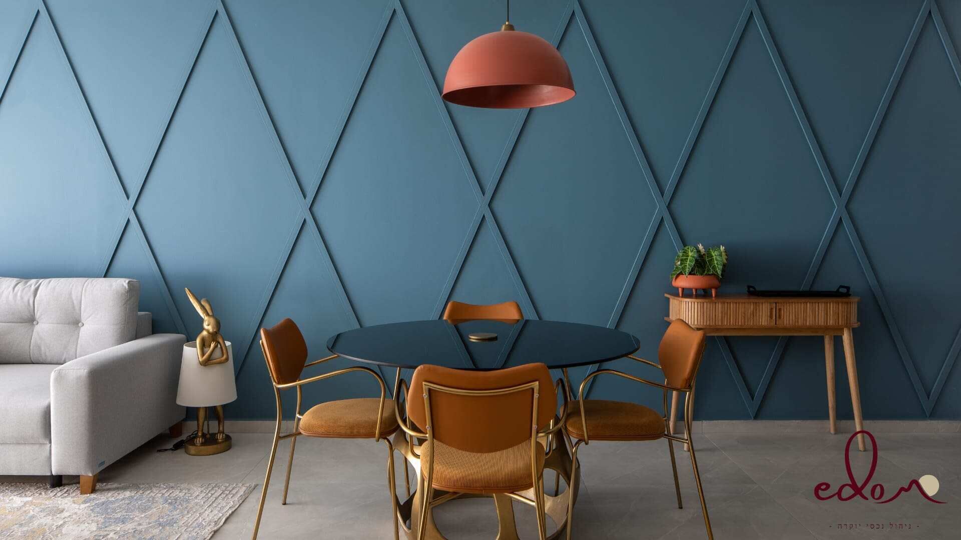 Un salon moderne comprenant un canapé, une table à manger avec des chaises, un luminaire suspendu et une petite table d’appoint avec une plante.