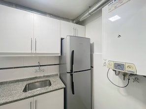 A kitchen with white cabinets, a stainless steel refrigerator, a granite countertop, and a water filtration system. - Charming Apartment in Recoleta 4 pax (Buenos Aires)