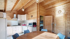 Un intérieur en bois comprenant une cuisine, une table à manger et des chaises.