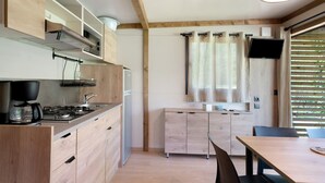 Eine moderne Küche mit Holzschränken, einem Gasherd und einem Essbereich mit Tisch und Stühlen.