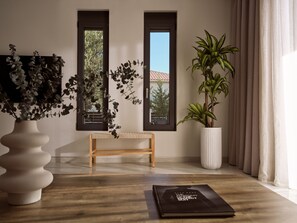 A modern room with a wooden bench, a large potted plant, and a book on the floor. - Solis Ortus Villa, a Sublime Sanctuary with Pool (Zakynthos)