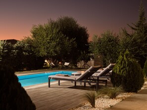 A swimming pool with lounge chairs and a wooden deck. - Solis Ortus Villa, a Sublime Sanctuary with Pool (Zakynthos)