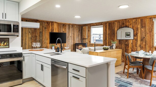 A modern kitchen with white cabinetry, a built-in microwave, and a large island with a sink. - The Writer's Cottage - 13m to Shenandoah NP, Hot Tub, Mountain Views, EV (Luray)