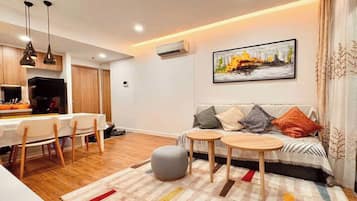 Phòng Suite Grand, 1 phòng ngủ, quyền sử dụng Club Lounge, quang cảnh hồ bơi | Khu phòng khách | Smart TV 65-inch có truyền hình cáp, lò sưởi, Netflix