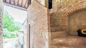 Un edificio rústico de piedra con chimenea de ladrillo y puerta de madera.