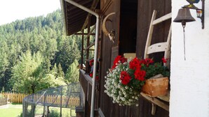 A wooden building with a balcony, a rooster decoration, and a bell. - Traditional Apartment "Waldstille" in Idyllic Nature, Balcony and Wi-Fi (San Lorenzo di Sebato)