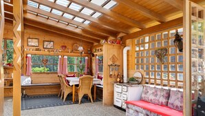 A cozy wooden interior with a dining area, a sofa, and a window with a view. - Traditional Apartment "Waldstille" in Idyllic Nature, Balcony and Wi-Fi (San Lorenzo di Sebato)