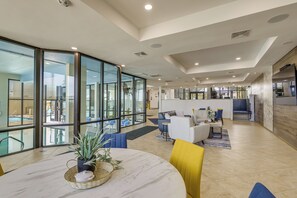 A spacious hotel lobby with a large glass wall, a round marble table, and modern furniture. - 3BR Beachfront PH Suite: Suntide III - Unit 1203 (South Padre Island)