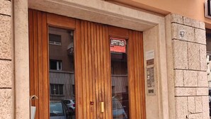 A building with two wooden doors, a sign reading "AFFITTASI", and a number "47" on the wall. - Lilla Eco House Vaticano (Rome)