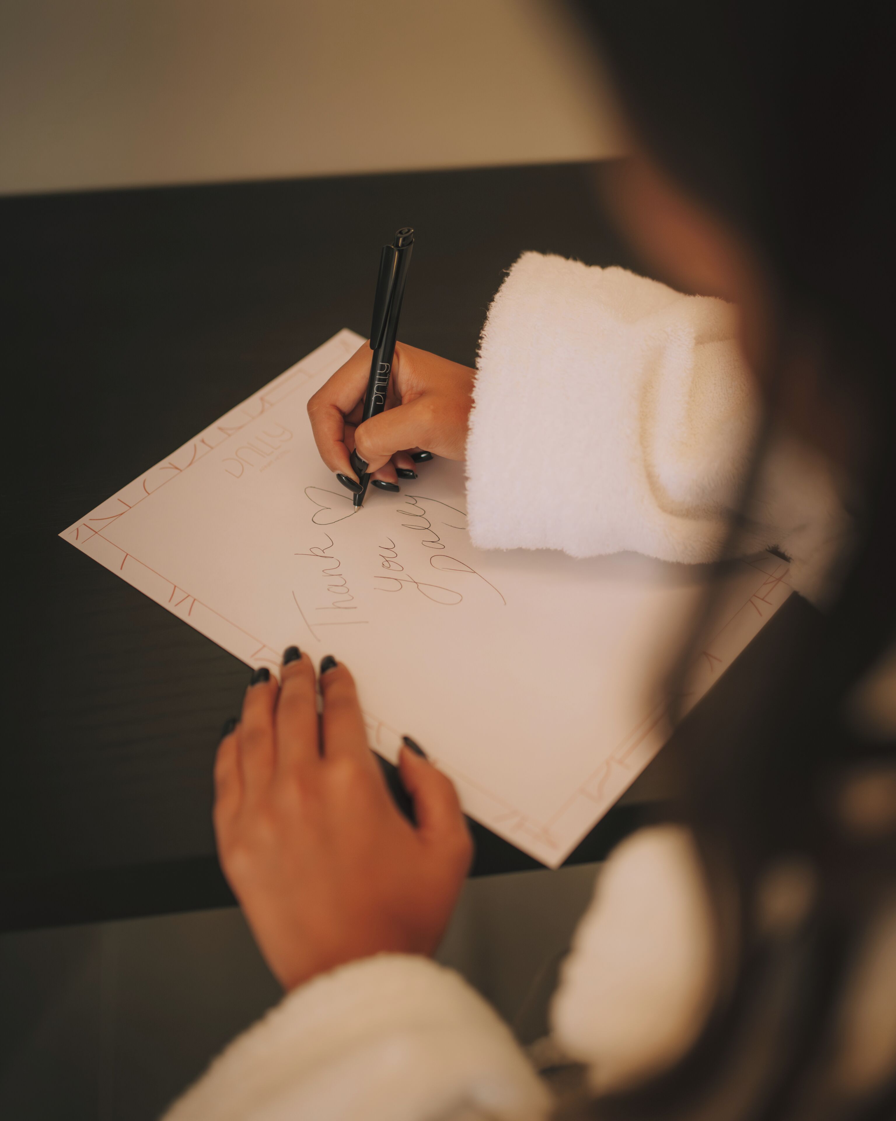 Une personne qui écrit sur une feuille de papier avec un stylo.