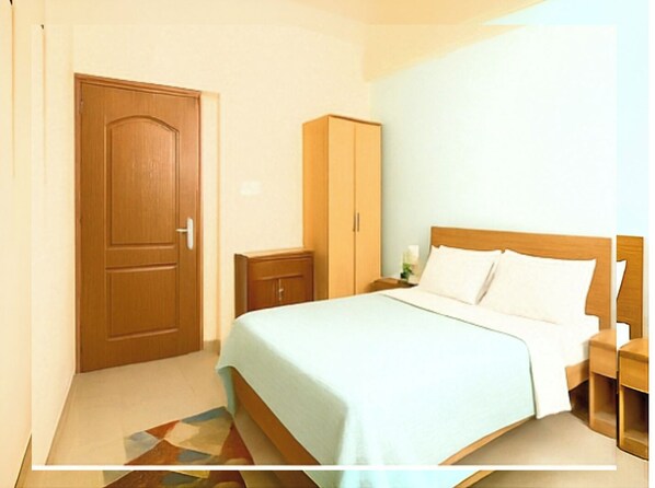 A bedroom with a bed, a wardrobe, and a nightstand.