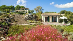 A villa with a garden, a small outdoor seating area, and a view of the surrounding landscape. - Villa Pelagos & guest house, undoubtedly has one of the best views in Corfu. (Corfu)