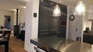 A modern kitchen with stainless steel appliances, a dining area with a table and chairs, and pendant lighting. - Magnificent villa with private pool in a quiet location (vidauban)