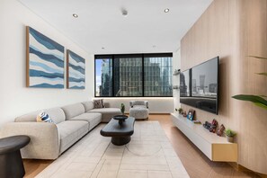 Ein modernes Wohnzimmer mit einer Couch, einem Couchtisch und einem Fernseher.