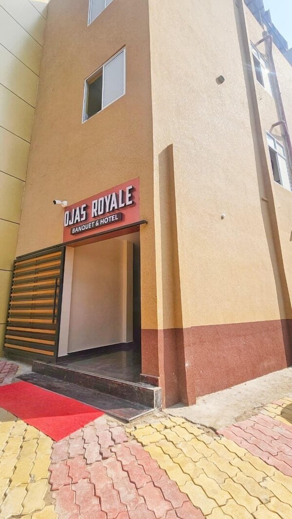 Een gebouw met een bord waarop staat: OJAS ROYALE BANQUET & HOTEL.