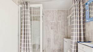 Une salle de bain avec une douche, des toilettes et un lavabo.