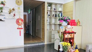 Un hall d’entrée spacieux, doté d’un sol ciré, d’un comptoir de réception et d’une étagère contenant divers objets.