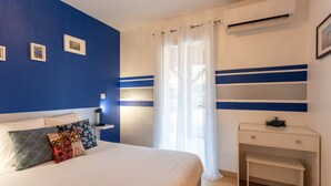 Une chambre à coucher comprenant un lit, une table de chevet et un bureau avec une chaise.