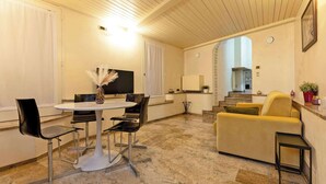 Ein modernes Wohnzimmer mit Essbereich, einer Couch und einem Fernseher.