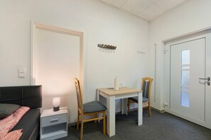A bedroom with a bed, bedside table with a lamp, a desk with a chair, and a wardrobe. - Well-Equipped and Cozy 2-Bedroom Accommodation in Beckingen (Beckingen)