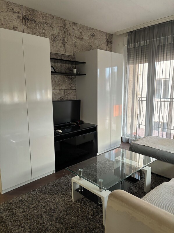 Apartamento Deluxe, patio, vistas al jardín | Zona de estar | Una televisión de pantalla plana