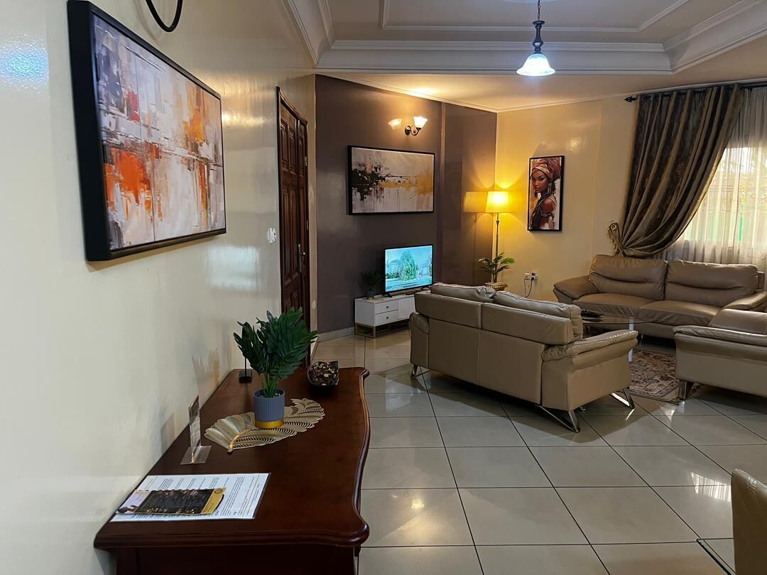 A living room with a sofa, a coffee table, a TV, and artwork on the walls.