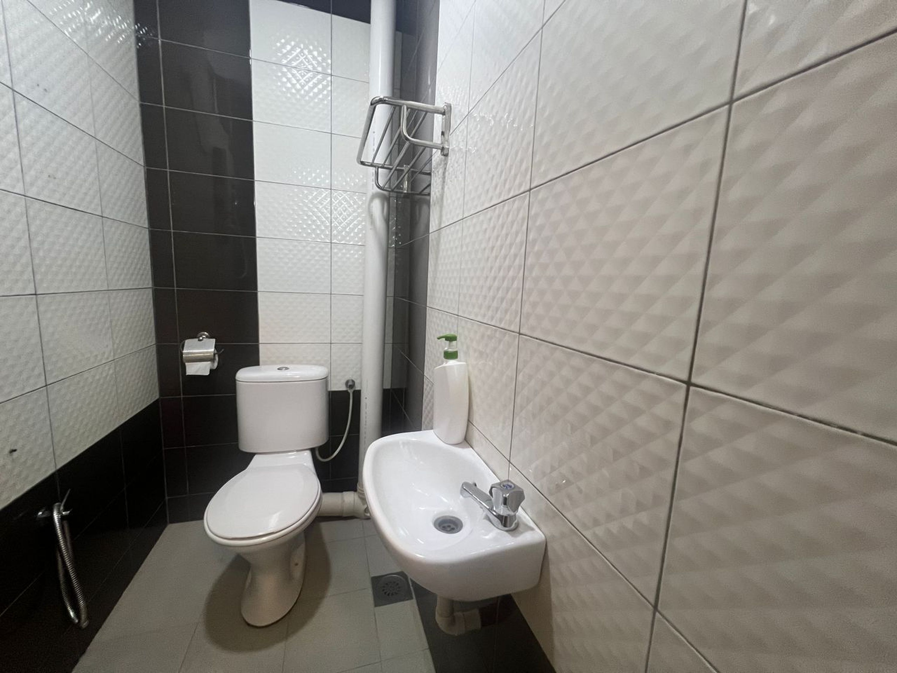 Uma casa de banho pequena e moderna com sanita, bidé e lavatório.