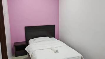 Un dormitorio con cama, mesita de noche, aire acondicionado instalado en la pared y luz de techo.