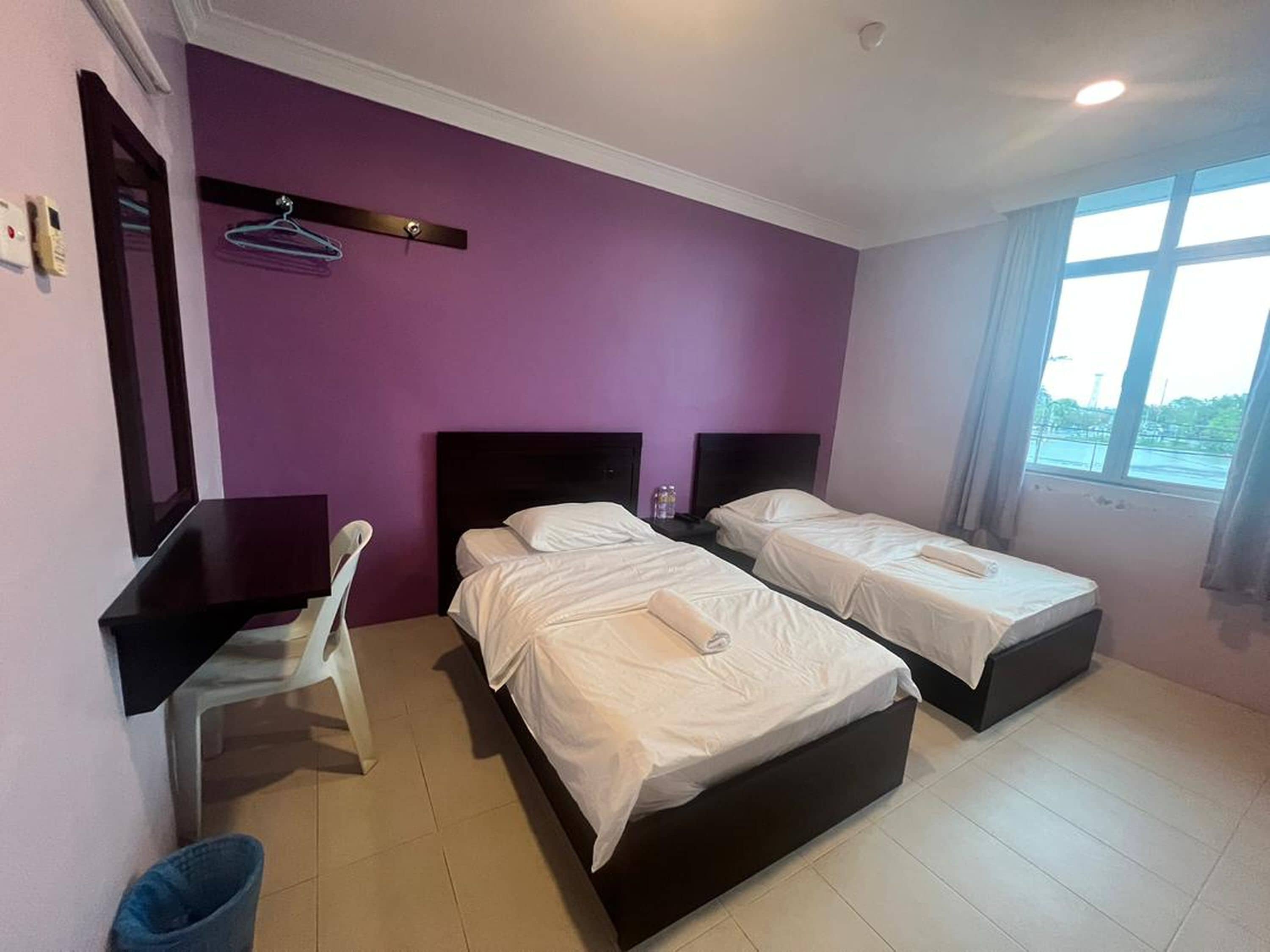 Una habitación de hotel con dos camas, un escritorio y una silla.