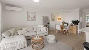 Ein modernes Wohnzimmer mit einer Couch, einem Couchtisch und einem Essbereich.