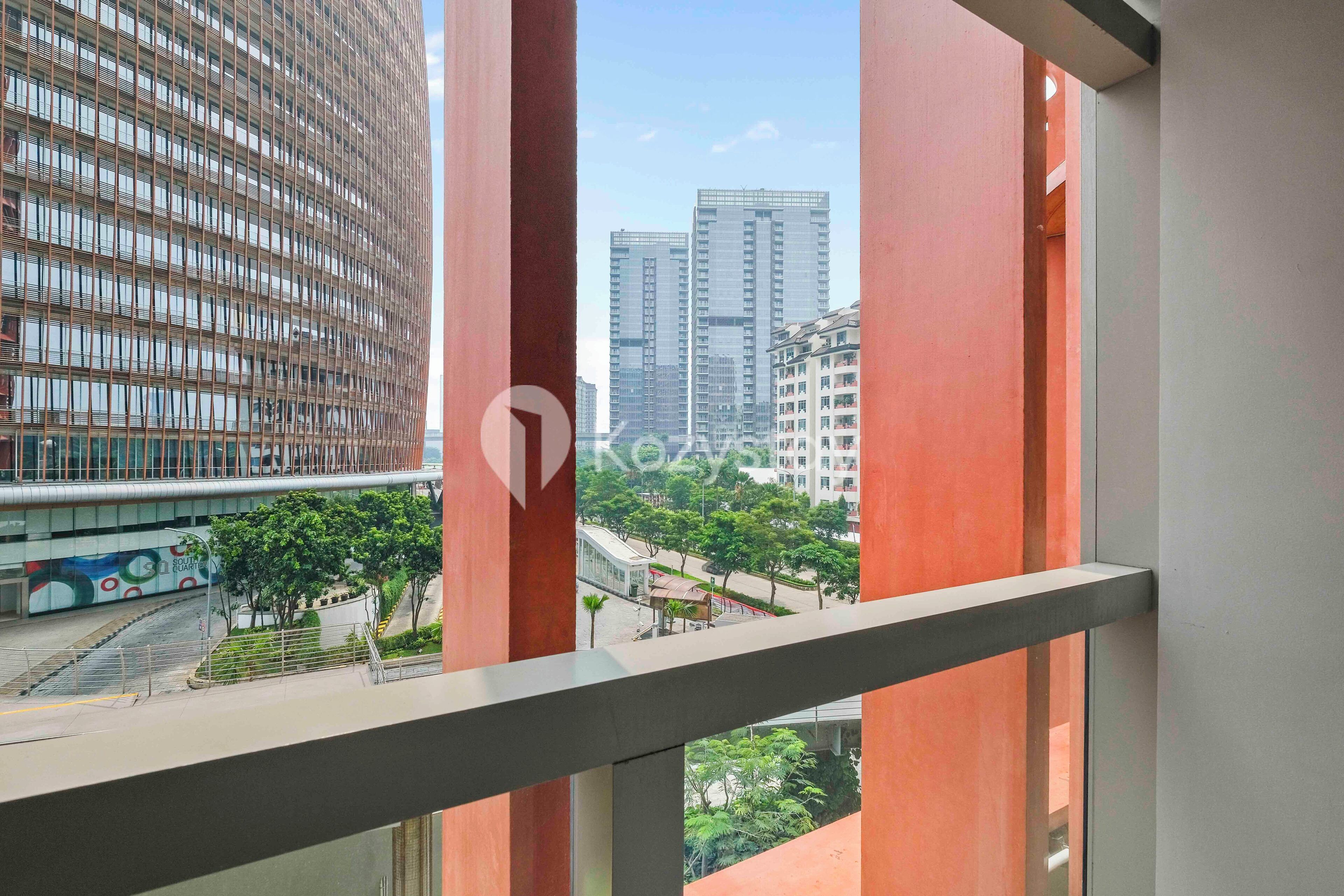 A view from a window with a metal frame, overlooking a cityscape with tall buildings and a road with trees and a bus.