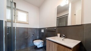 Un bagno moderno con doccia, toilette e lavandino.