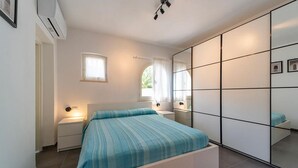 Una camera da letto con un letto, comodini, uno specchio e un armadio.