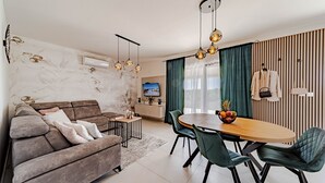 A modern living room with a sofa, dining table, chairs, and a TV. - Villa Antea by Villas Guide (Vela Luka)